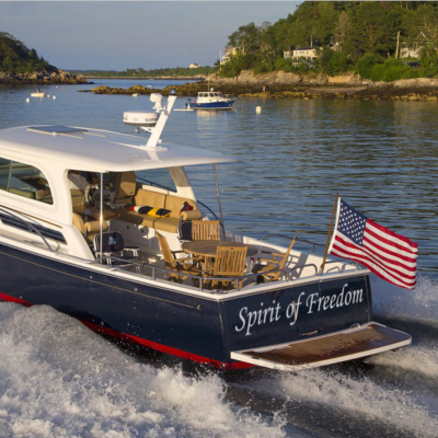 Atlas Wrap Co. offers custom cut vinyl letter decals for boats. This example shows a patriotic boat in the water with the name "Spirit of Freedom".