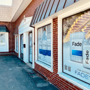 Storefront windows using perforated vinyl graphics to advertise their brand. Printed and installed by Atlas Wrap Co.