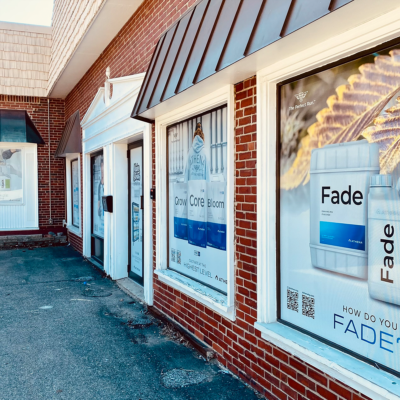 Storefront windows using perforated vinyl graphics to advertise their brand. Printed and installed by Atlas Wrap Co.