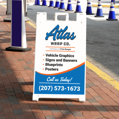 This is a mockup of an Atlas Wrap Co A-Frame sign next to a road, as an example of the products that we offer.